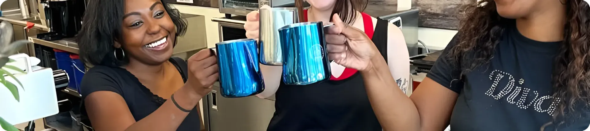 Momentum Coffee customers toasting with their drinks in the cafe