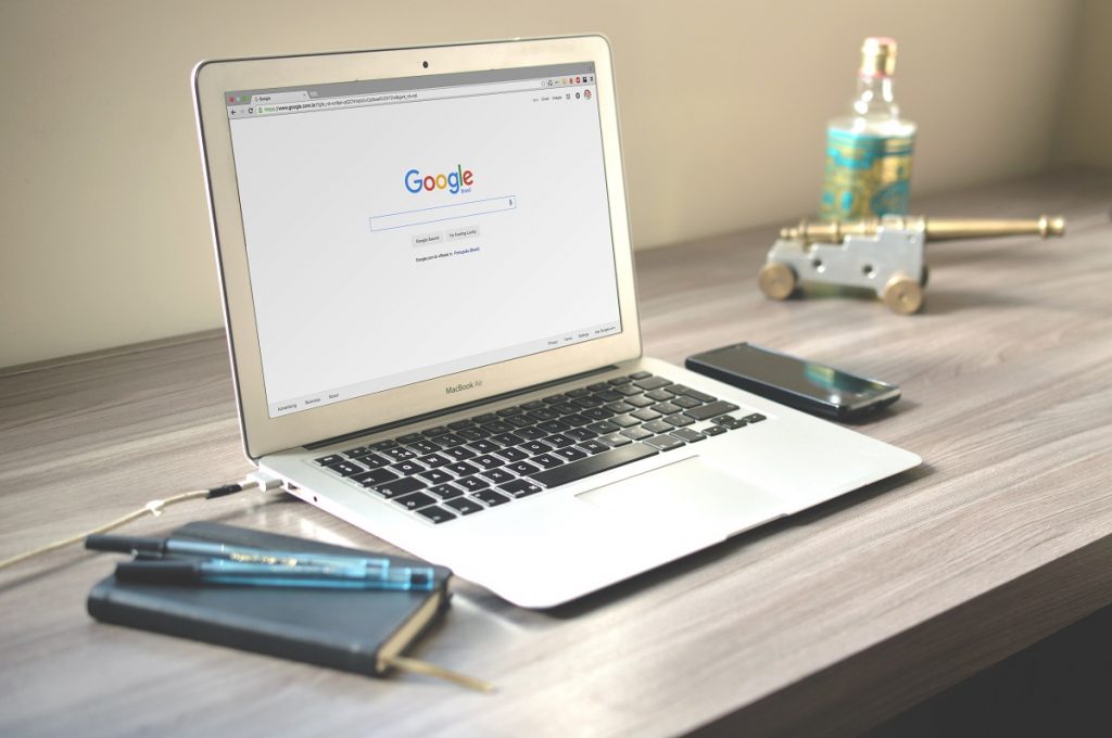 A laptop on a desk open to Google