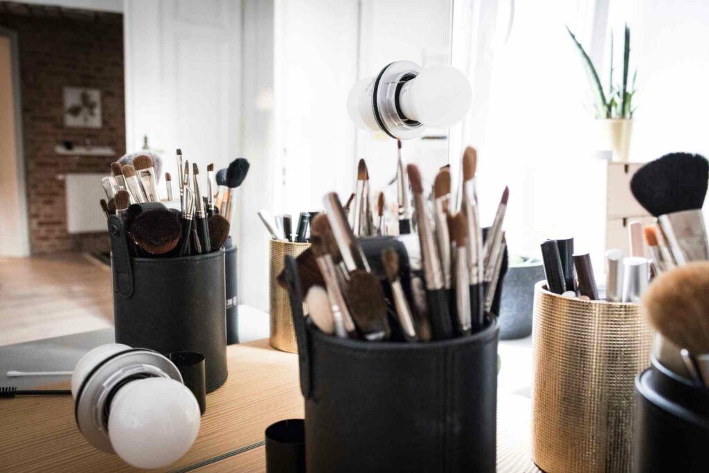 Makeup brushes and other products on a desk at a business, ready to be photographed for Instagram