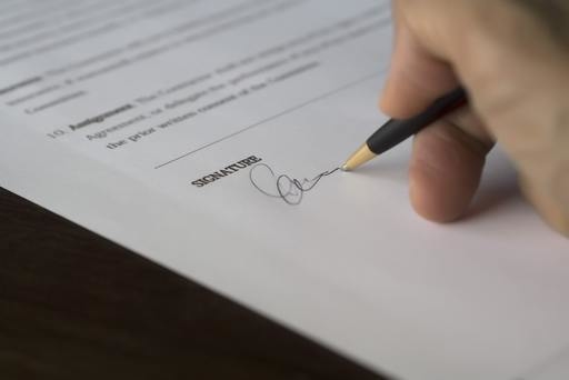 A person adding their signature to a document