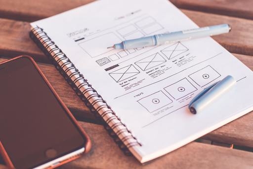 A sketch of a website design on a notepad next to a smartphone