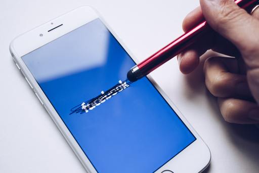 A smartphone with the facebook logo crossed out with a stylus