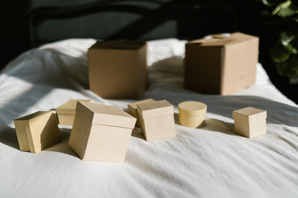A collection of small dropshipped boxes arriving at a home and laid on a bed.